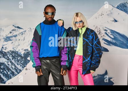 coppia multietnica in posa in abiti invernali con montagna sullo sfondo, uomo e donna afroamericani Foto Stock