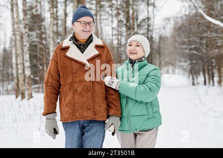 Marito e moglie felici che camminano nel parco invernale con il freddo Foto Stock