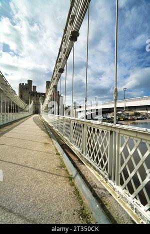 Guardando a ovest sul bianco ponte sospeso Conwy fino al castello di Conwy. Galles del Nord, Regno Unito Foto Stock