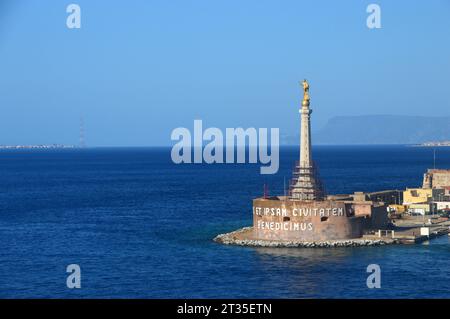 Uno Statuto d'oro della Madonna della lettera si erge sull'ingresso al Porto di Messina, Sicilia, Italia, UE. Foto Stock