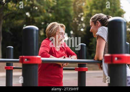 Nonna e nipote training su barre in un parco Foto Stock