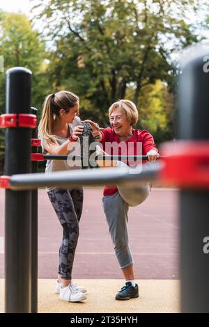Nonna e nipote training su barre in un parco Foto Stock