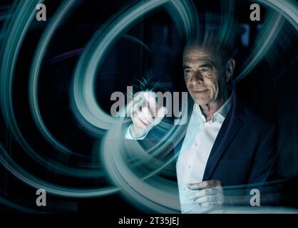 Immagine composita digitale di un uomo d'affari che crea un modello a vortice sull'interfaccia grafica utente Foto Stock