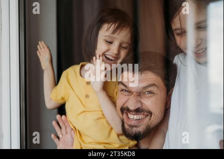 Padre sorridente e figli che si divertono a casa Foto Stock