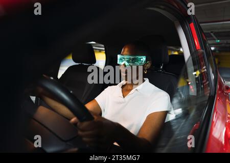 Giovane donna d'affari che indossa occhiali intelligenti e che guida un'auto Foto Stock