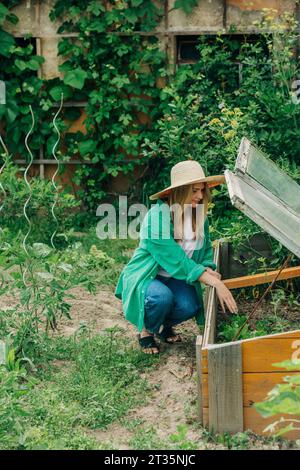 Donna che piantava semi in serra Foto Stock