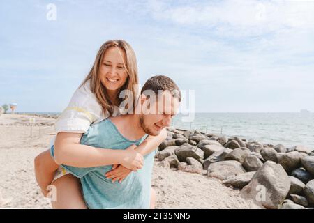 Un uomo felice che dà un giro a una donna Foto Stock