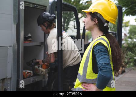 Lavoratore in piedi vicino al dumper con il conducente sullo sfondo Foto Stock