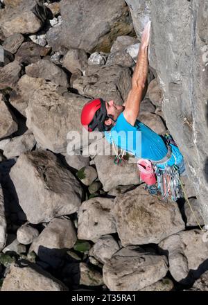 Uomo determinato che sale su una montagna rocciosa nel Pembrokeshire Foto Stock