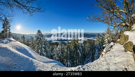 Sole luminoso che splende sulle montagne innevate con il cielo sullo sfondo Foto Stock