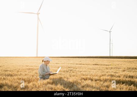 Agronomo che lavora su un computer portatile nel campo del grano Foto Stock