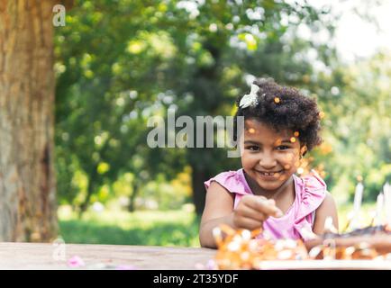 Felice ragazza che festeggia il compleanno in giardino Foto Stock