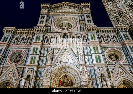 Firenze, Italia. La facciata del Duomo (Duomo), rivestita di marmo colorato, vista di notte. il 14c campanile di Giotto è sulla destra Foto Stock