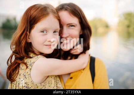 Figlia felice che abbraccia la madre nel parco Foto Stock