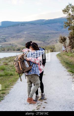Coppia che si abbracciano a vicenda in piedi sul sentiero Foto Stock