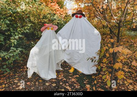 Ragazze giocose in costume di colore bianco in piedi in giardino Foto Stock