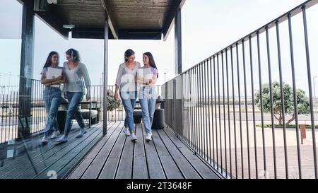 Due giovani donne che camminano fianco a fianco sul balcone Foto Stock