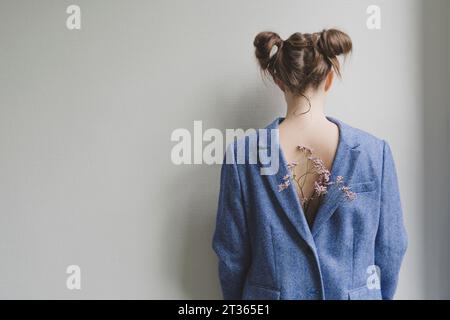 Ragazza adolescente che indossa un blazer blu all'indietro con fiori sulla schiena Foto Stock