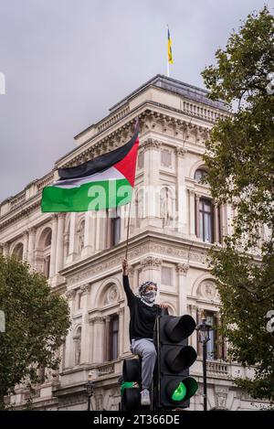 Protesta in cima a un semaforo che sgancia una bandiera palestinese nella Whitehall, protesta pro-palestinese nel centro di Londra il 21/10/2023, Inghilterra, Regno Unito Foto Stock