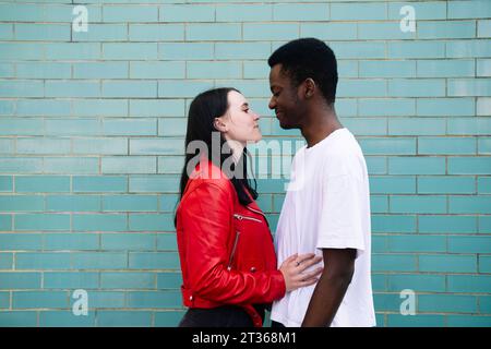 Una coppia amorevole in piedi vicino al muro di mattoni Foto Stock