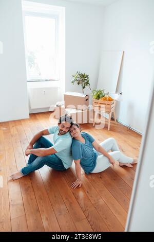 Coppia amorevole seduta sul pavimento a casa Foto Stock