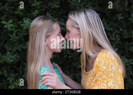 Madre e figlia felici che si strofinano il naso al parco Foto Stock