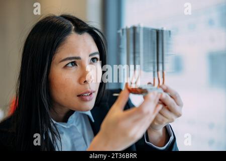 Ingegnere che analizza i semiconduttori in ufficio Foto Stock
