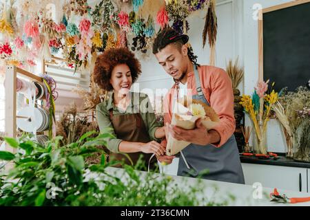 Fioristi che preparano bouquet di fiori alla reception del negozio Foto Stock