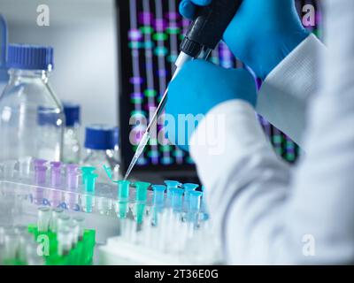 Scienziato che pipetta il campione di DNA nella provetta eppendorf per l'analisi genetica Foto Stock