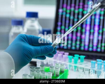 Scienziato che pipetta il campione di DNA in una fiala per l'analisi Foto Stock