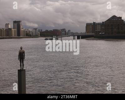 Limehouse, Londra, Regno Unito - 21 ottobre 2023: Una delle sculture in ghisa di Sir Antony Gormley, un'altra volta, su un basamento nel Tamigi a Limehouse. Foto Stock