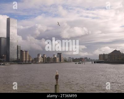 Limehouse, Londra, Regno Unito - 21 ottobre 2023: Una delle sculture in ghisa di Sir Antony Gormley, un'altra volta, su un basamento nel Tamigi a Limehouse. Foto Stock