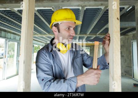 muratore di tetti che lavora sulla struttura dell'edificio in cantiere Foto Stock