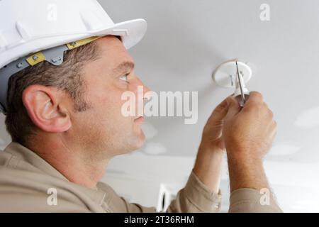 primo piano di un elettricista che installa i cavi elettrici Foto Stock