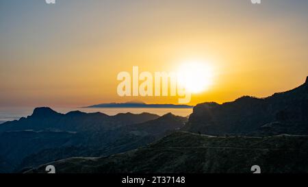 Paesaggio dell'isola di Tenerife con il sole sopra e il mare di nuvole sotto dall'isola di Gran Canaria. In primo piano è possibile vedere l'albero Foto Stock