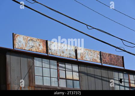 LONG BEACH, CALIFORNIA - 18 OCT 2023: Cartello sbiadito e arrugginito sull'edificio Whyatt Welding Works. Foto Stock