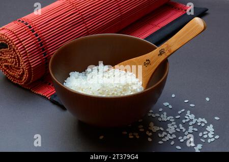 Riso, riso bianco in recipiente con mestolo di legno Foto Stock