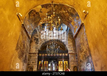 Grandangolo, chiesa interna, icone, volta a tunnel, pareti ocra, lampadario, muro d'altare, Myriokephala, Monastero ortodosso, Creta, Grecia Foto Stock