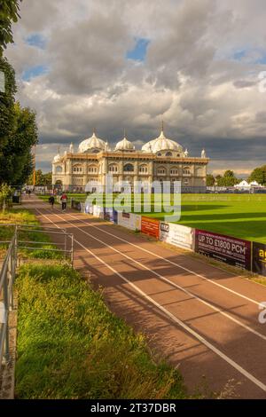 Guardando il Siri Guru Nanak Darbar Gurdwara dal vicino campo sportivo con luce notturna Foto Stock