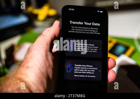 Londra, Regno Unito - 28 settembre 2023: Un utente maschile imposta l'ultimo iPhone 15 Pro Max, esplorando le opzioni di trasferimento dati. Il processo include il download da iCloud o il trasferimento di dati da un altro iPhone Foto Stock
