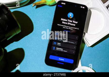 Londra, Regno Unito - 28 settembre 2023: Una prospettiva dall'alto verso il basso cattura il processo di configurazione dell'ultimo iPhone 15 Pro Max. Ciò include la creazione del nuovo iPhone, il trasferimento di app e dati, la configurazione del portafoglio, la regolazione delle impostazioni e la connessione a un orologio Foto Stock