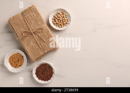 Coltivare microgreen. Semi e tappetini diversi su un tavolo in marmo bianco, con disposizione piatta. Spazio per il testo Foto Stock