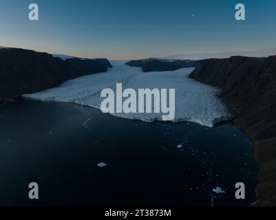 Aereo di un grande ghiacciaio di notte con la Luna Foto Stock