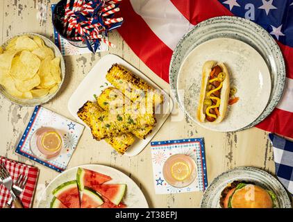 Il 4 luglio hotdog con anguria, patatine fritte, mais e limonata rosa Foto Stock