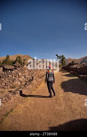 Vista posteriore della donna anziana nel parco archeologico "Wiracocha" nelle rovine di Raqchi Foto Stock