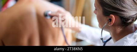 Il terapeuta ascolta l'uomo che respira usando lo stetoscopio Foto Stock