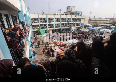 Le donne palestinesi fuggite dalle loro case guardano in basso mentre i loro figli partecipano ai giochi organizzati da operatori umanitari in una scuola gestita dalle Nazioni Unite, a Khan Yunis, nella Striscia di Gaza meridionale. I palestinesi sfollati si rifugiano in una scuola gestita dalle Nazioni Unite, a Khan Yunis, nella Striscia di Gaza meridionale, in mezzo alle battaglie in corso tra Israele e il gruppo palestinese Hamas. Migliaia di persone, sia israeliane che palestinesi, sono morte dal 7 ottobre 2023, dopo che i militanti palestinesi di Hamas con base nella Striscia di Gaza sono entrati nel sud di Israele in un attacco a sorpresa che ha portato Israele a dichiarare guerra ad Hamas Foto Stock