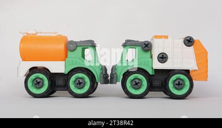 Due giocattoli in plastica fai da te isolati su sfondo bianco. camion per l'acqua e camion per la raccolta rifiuti. Giocattolo fai-da-te per aumentare la creatività dei bambini. Foto Stock