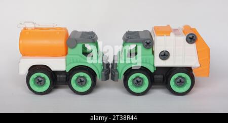 Due giocattoli in plastica fai da te isolati su sfondo bianco. camion per l'acqua e camion per la raccolta rifiuti. Giocattolo fai-da-te per aumentare la creatività dei bambini. Foto Stock