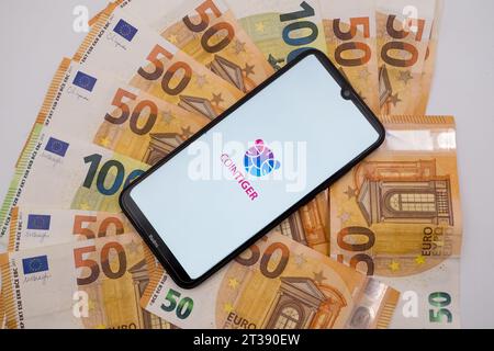 Atene, Grecia. 24 ottobre 2023. In questa foto, il logo CoinTiger è stato visualizzato sullo schermo di uno smartphone su banconote da 50 e 100 euro ad Atene, in Grecia, il 24 ottobre 2023. (Illustrazione fotografica di Nikolas Kokovlis/NurPhoto)0 crediti: NurPhoto SRL/Alamy Live News Foto Stock